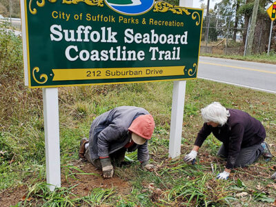Gardeners at sign of Suffolk Seaboard Coastline Trail, Suburban Drive